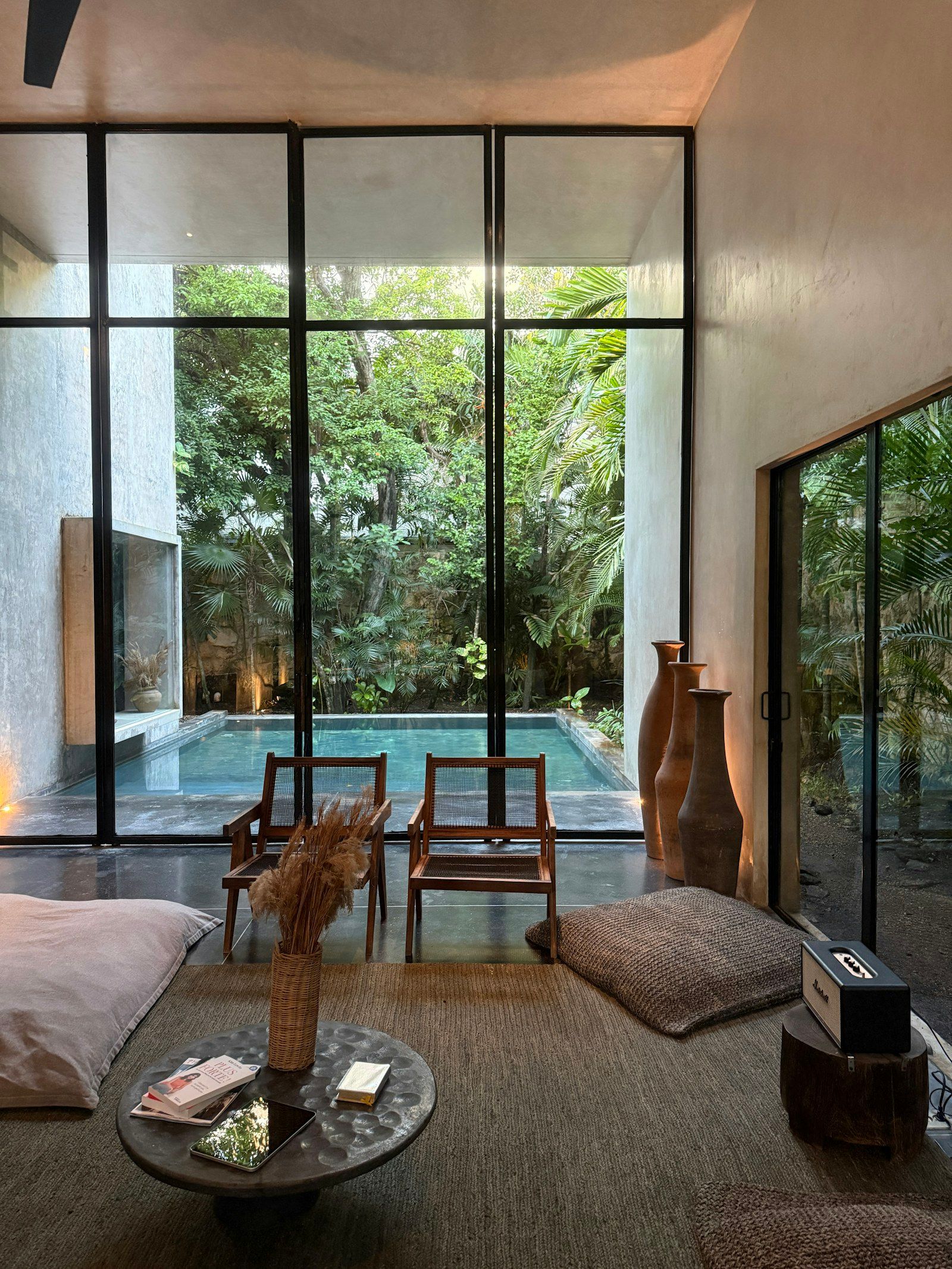 A calm living room opening onto a pool and a garden